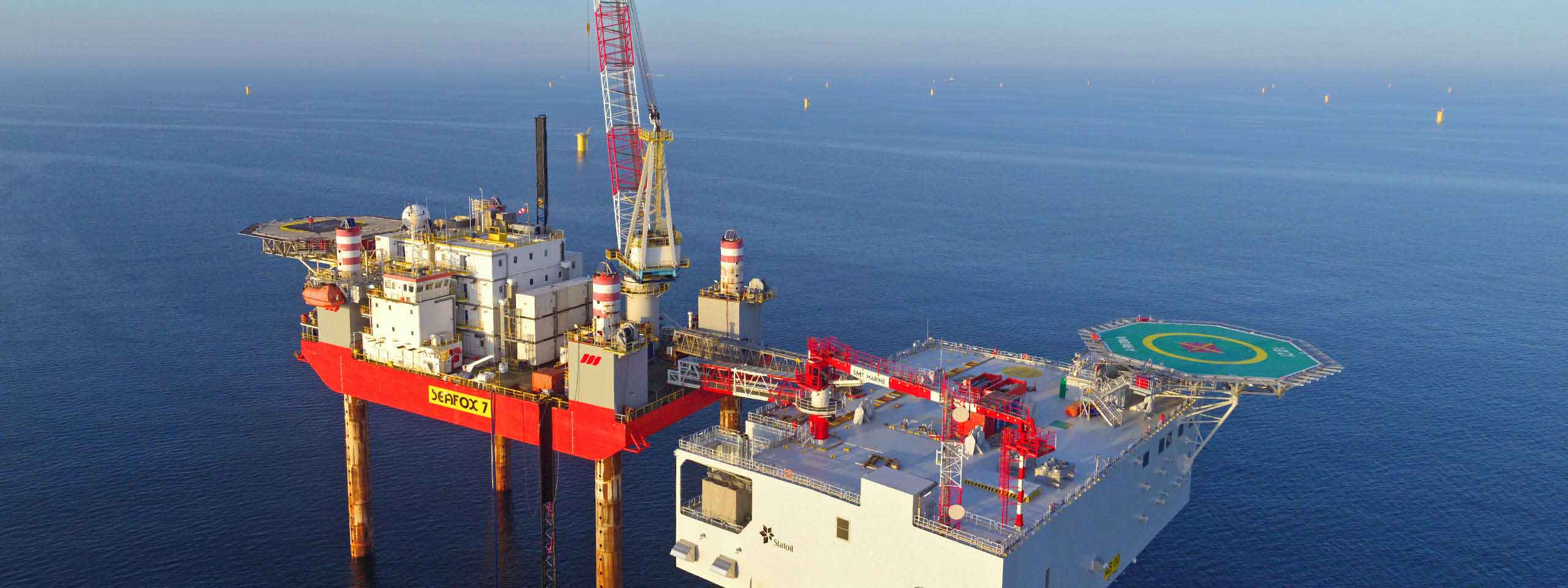 Eine Offshore-Plattform namens Seafox 7 steht im Wasser, umgeben von ruhigem Meer und unter blauem Himmel.
