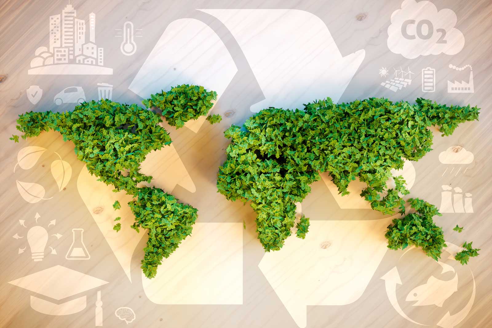 Eine Weltkarte aus grünen Blättern auf einer Holzoberfläche, umgeben von Umweltikonen und Recycling-Symbolen.