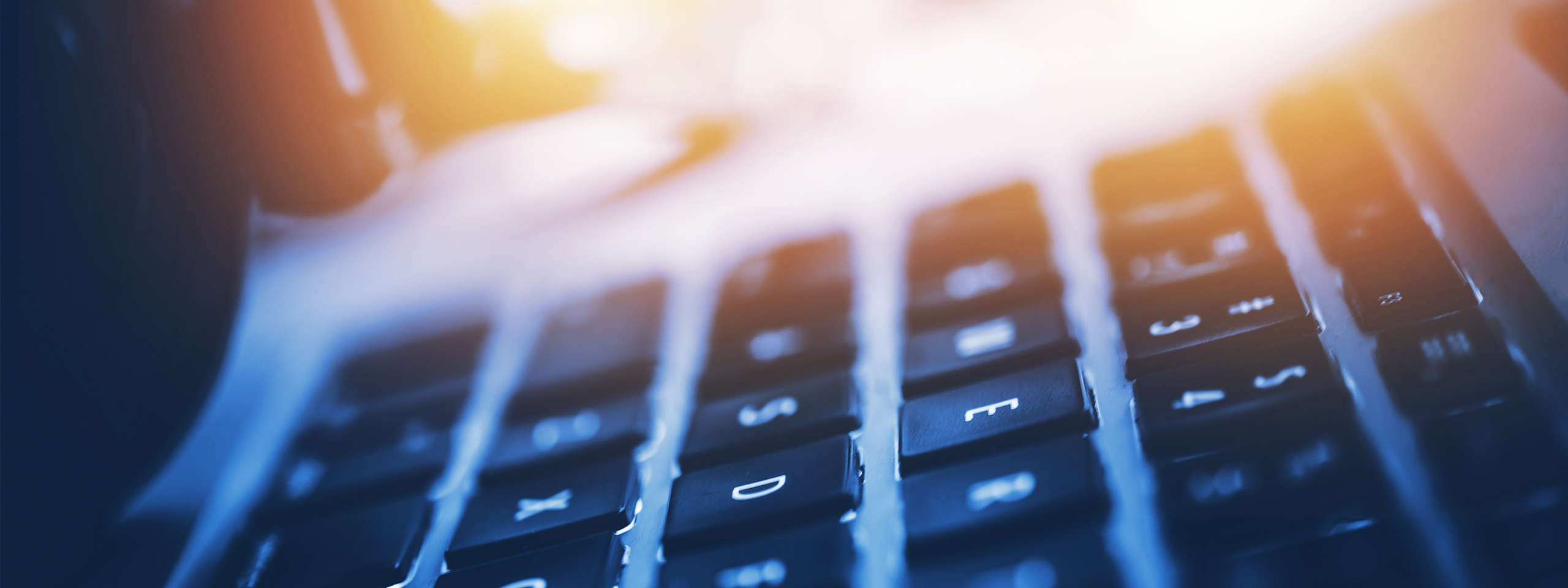 Nahaufnahme einer Tastatur mit weichem Licht, die Tasten sind sichtbar und die Farbe ist ein sanftes Blau-Orange.