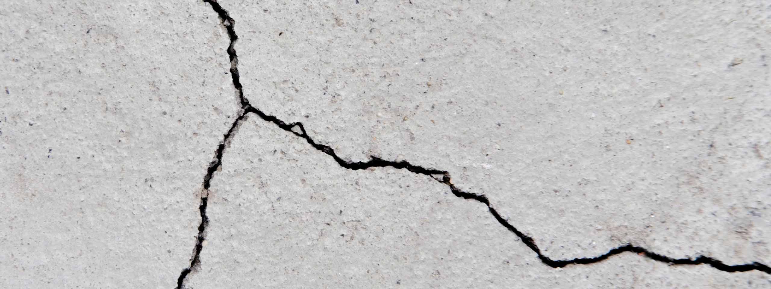 Ein Riss im Beton ist sichtbar, der sich unregelmäßig über die Oberfläche zieht.