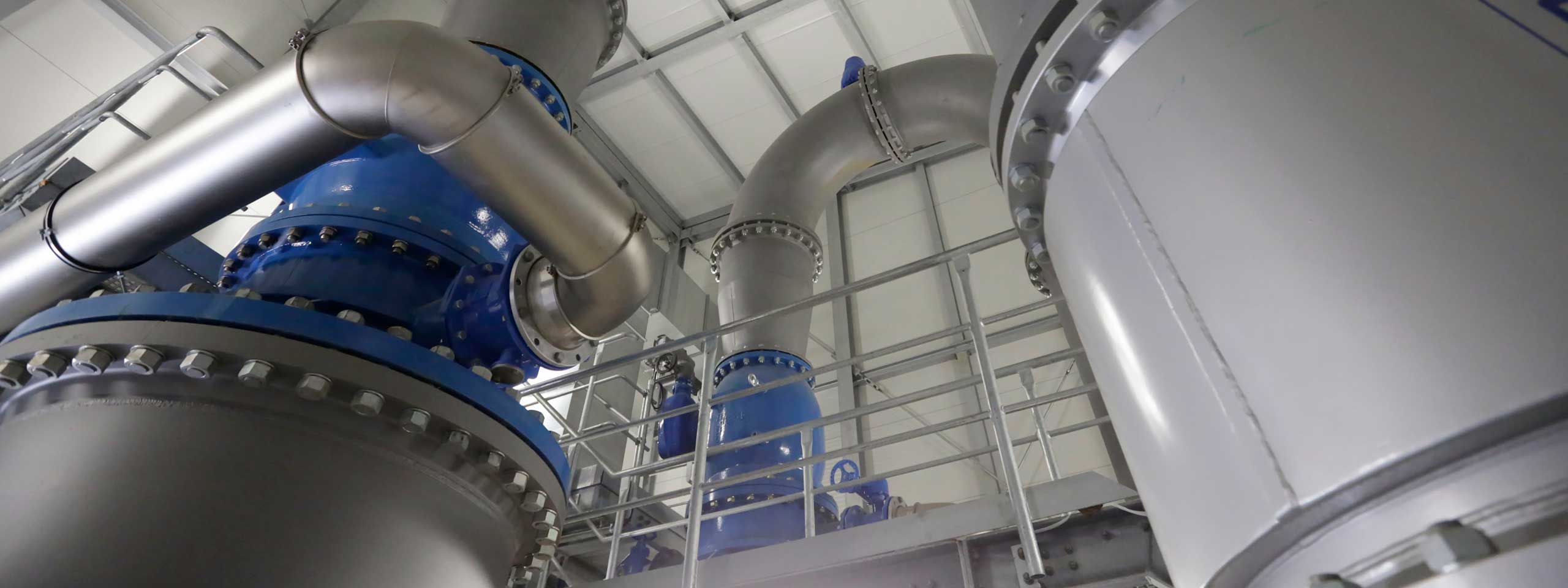 Eine industrielle Anordnung von Rohrleitungen und Ventilen in einem modernen Anlageninneren.