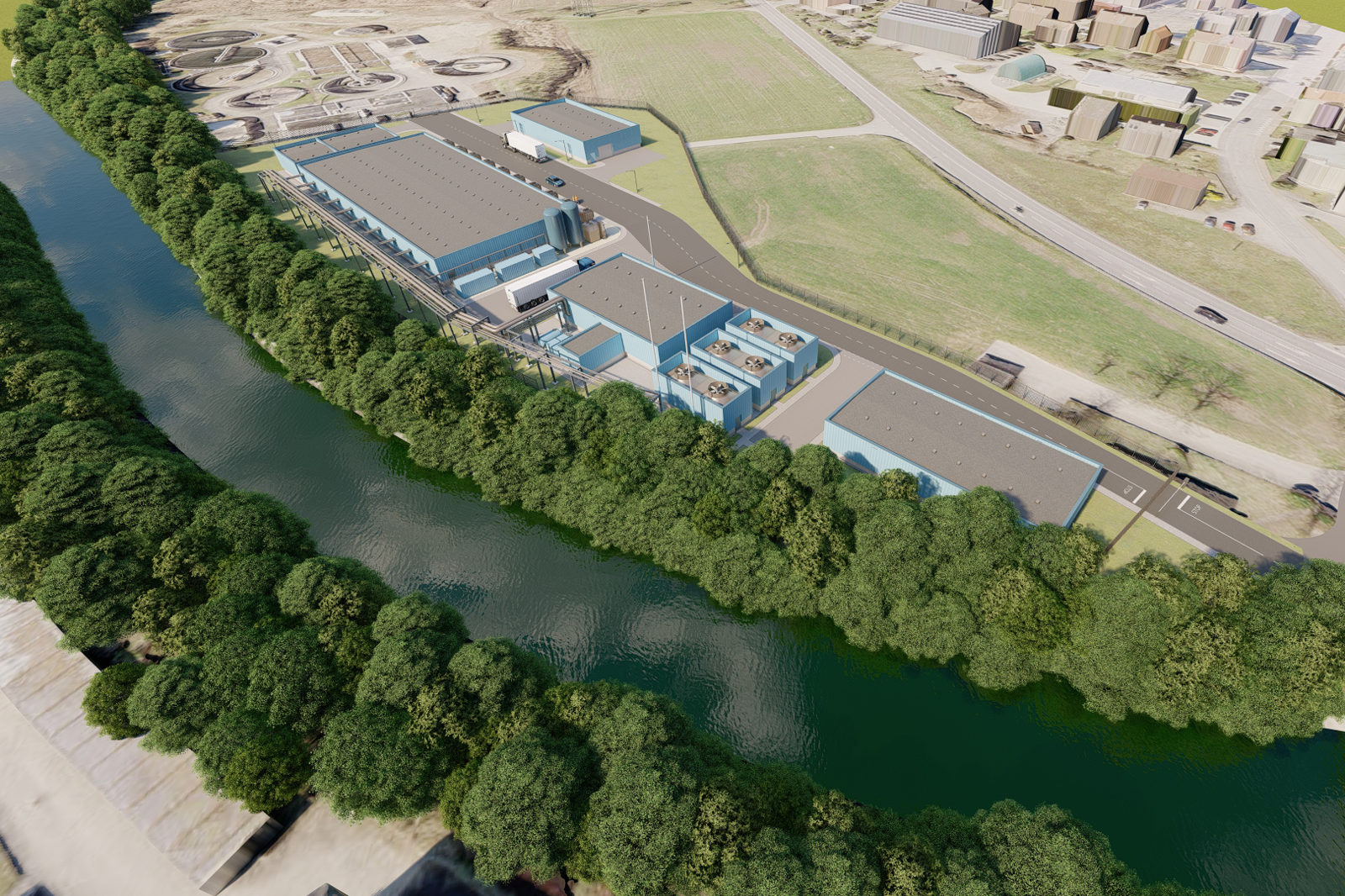 Luftaufnahme einer Industrieanlage am Ufer eines Flusses, umgeben von Grünflächen und Wohngebäuden.