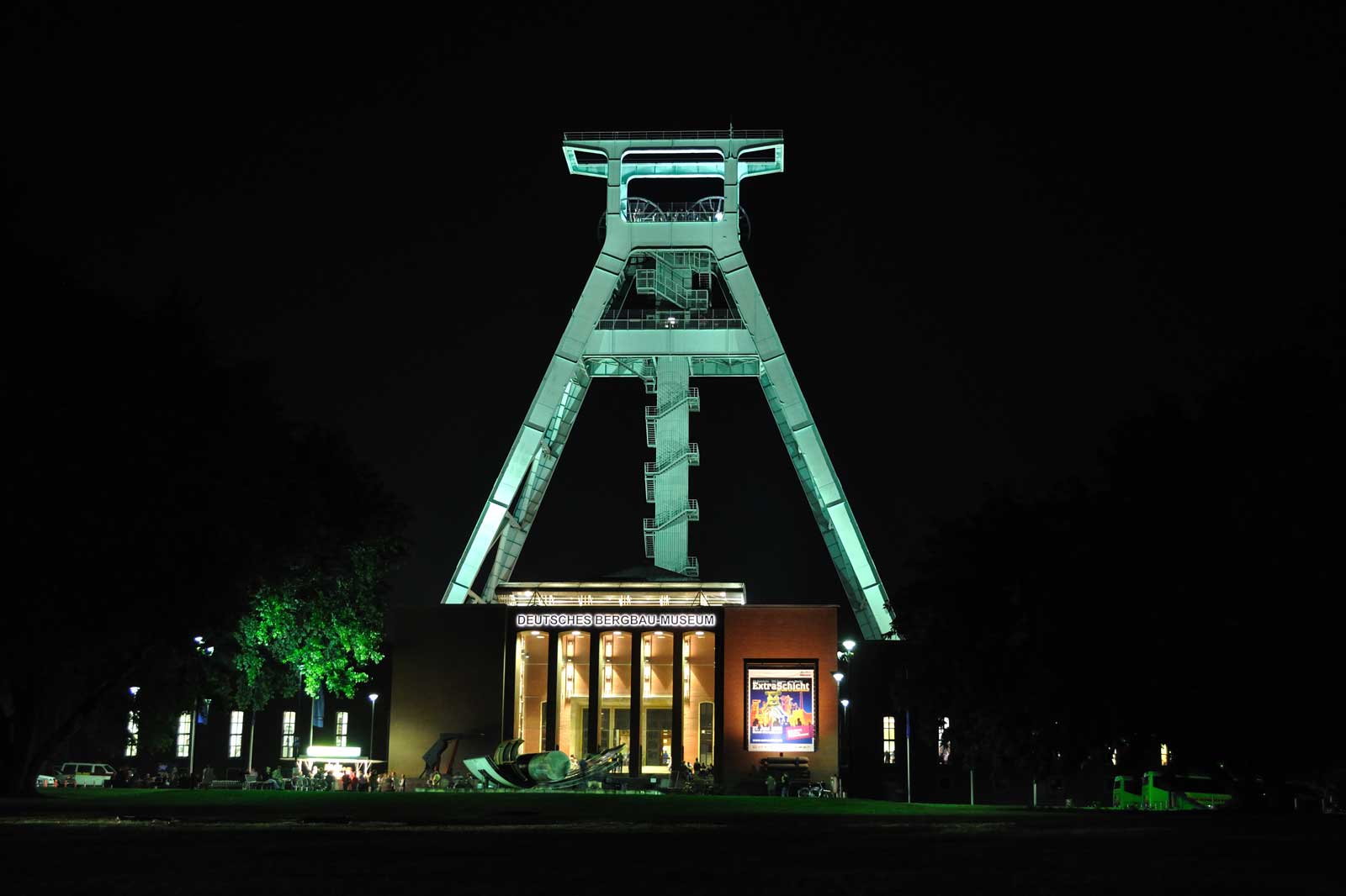 Das Deutsche Bergbau-Museum bei Nacht, beleuchtet mit grünem Licht, zeigt die beeindruckende Fördergerüste.