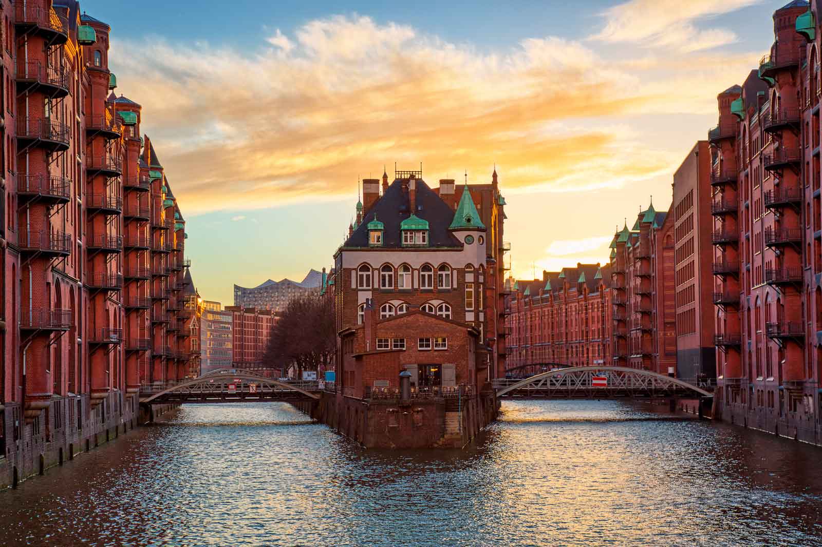 Ein schöner Sonnenuntergang über den historischen Speicherhäusern in Hamburg, mit einem alten Gebäude in der Mitte.